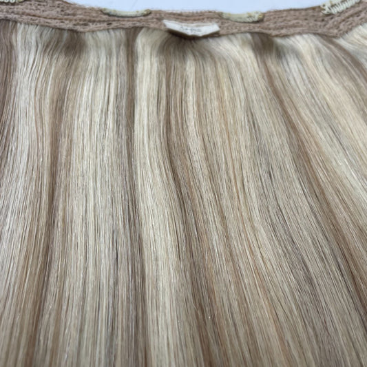 Capilli Extensions Halo extensions van 100g tot 300g met lang, glanzend haar op een witte achtergrond.